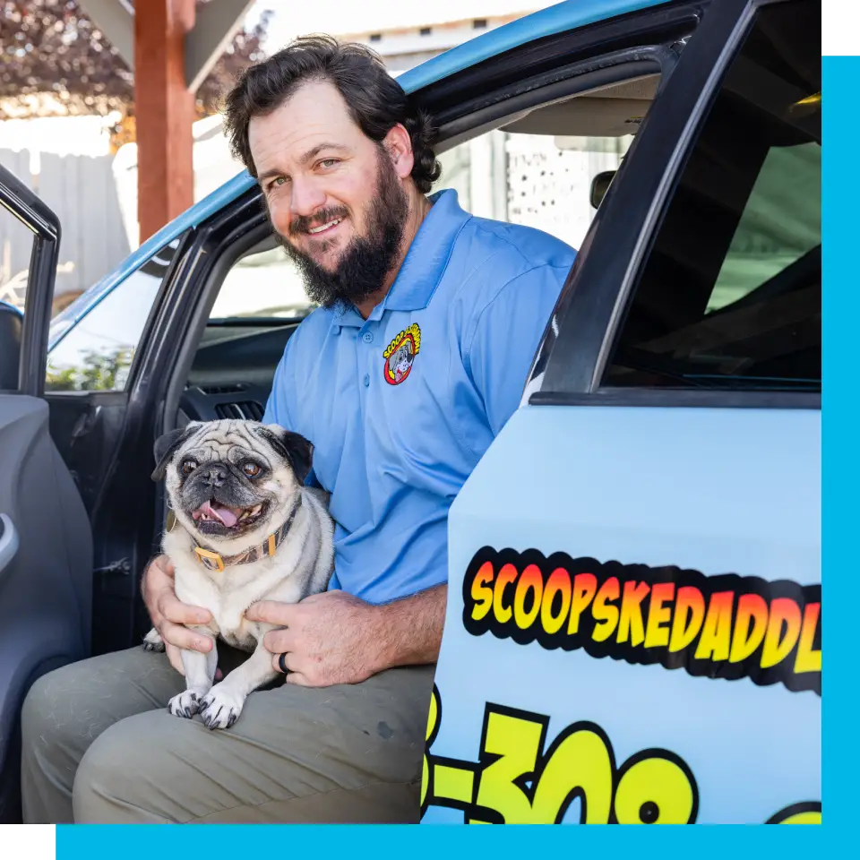 A man holding his dog in the back of a car.